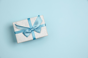 Image showing Gift, present box. Monochrome stylish composition in blue color. Top view, flat lay.