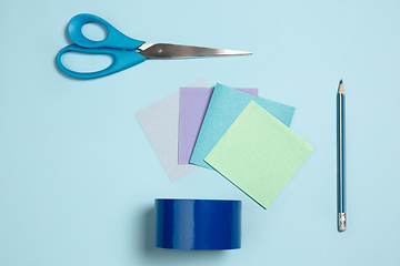 Image showing Sticker papers, scissors, pen. Monochrome stylish composition in blue color. Top view, flat lay.