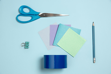 Image showing Sticker papers, scissors, pen. Monochrome stylish composition in blue color. Top view, flat lay.