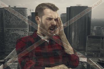 Image showing Stressed man holding head with hands on abstract city background. Double exposure. Virus alert, coronavirus pandemic.