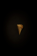 Image showing Golden icecream waffle on a black background, stylish minimalistic composition with copyspace