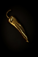 Image showing Golden pepper on a black background, stylish minimalistic composition with copyspace