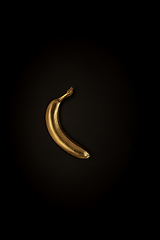 Image showing Golden banana on a black background, stylish minimalistic composition with copyspace