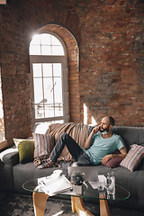 Image showing Young man doing yoga at home while being quarantine and freelance working