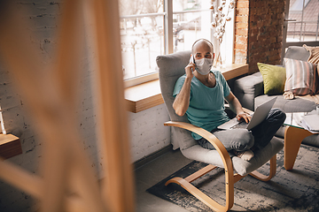 Image showing Young man doing yoga at home while being quarantine and freelance working