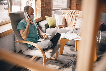 Image showing Young man doing yoga at home while being quarantine and freelance working