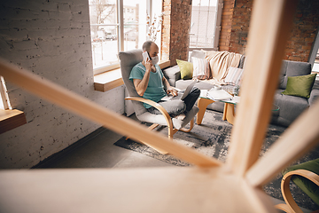 Image showing Young man doing yoga at home while being quarantine and freelance working