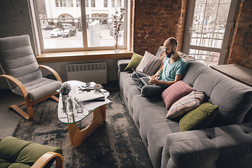 Image showing Young man doing yoga at home while being quarantine and freelance working