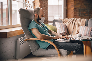 Image showing Young man doing yoga at home while being quarantine and freelance working