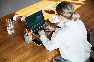 Image showing Woman working in office alone during coronavirus or COVID-19 quarantine, wearing face mask