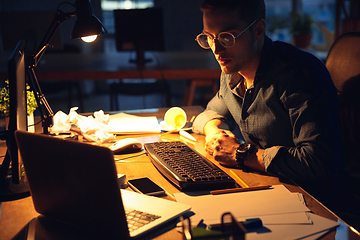 Image showing Man working in office alone during coronavirus or COVID-19 quarantine, staying to late night