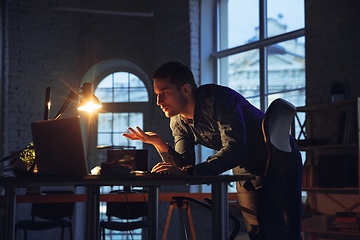 Image showing Man working in office alone during coronavirus or COVID-19 quarantine, staying to late night