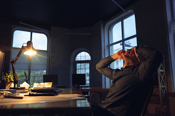 Image showing Man working in office alone during coronavirus or COVID-19 quarantine, staying to late night