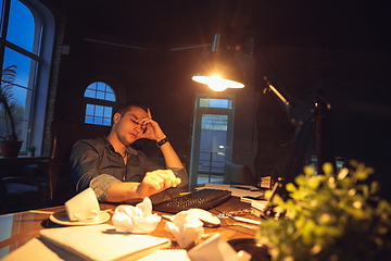 Image showing Man working in office alone during coronavirus or COVID-19 quarantine, staying to late night