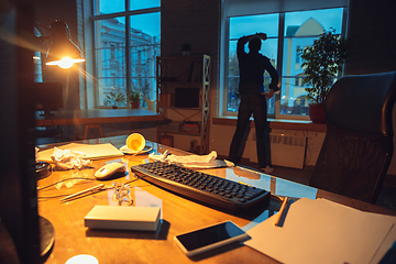 Image showing Man working in office alone during coronavirus or COVID-19 quarantine, staying to late night