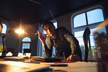 Image showing Man working in office alone during coronavirus or COVID-19 quarantine, staying to late night