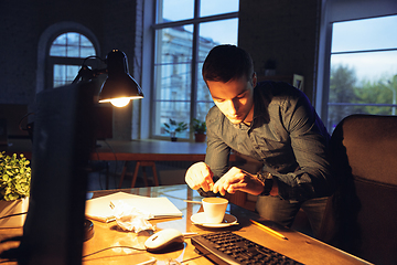 Image showing Man working in office alone during coronavirus or COVID-19 quarantine, staying to late night