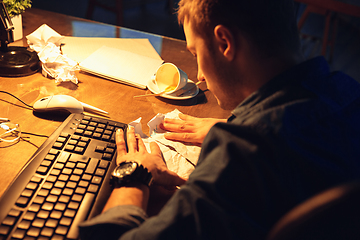 Image showing Man working in office alone during coronavirus or COVID-19 quarantine, staying to late night