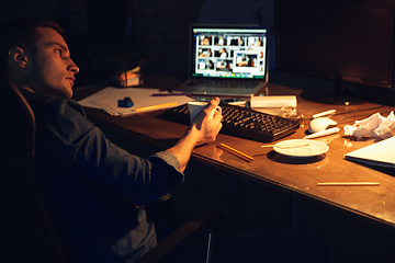 Image showing Man working in office alone during coronavirus or COVID-19 quarantine, staying to late night