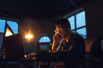 Image showing Man working in office alone during coronavirus or COVID-19 quarantine, staying to late night