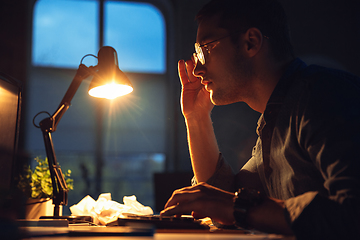 Image showing Man working in office alone during coronavirus or COVID-19 quarantine, staying to late night