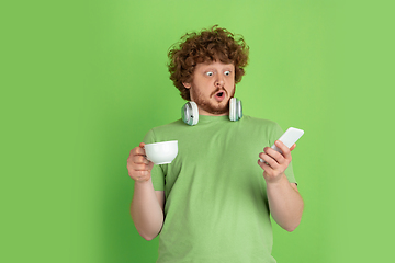 Image showing Caucasian young man\'s monochrome portrait on green studio background