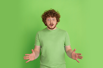 Image showing Caucasian young man\'s monochrome portrait on green studio background