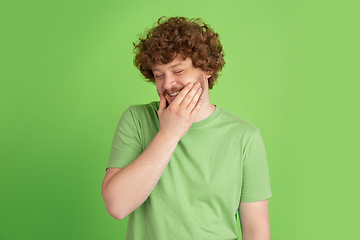 Image showing Caucasian young man\'s monochrome portrait on green studio background