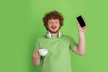 Image showing Caucasian young man\'s monochrome portrait on green studio background