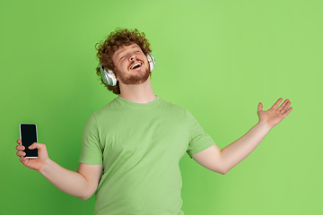 Image showing Caucasian young man\'s monochrome portrait on green studio background