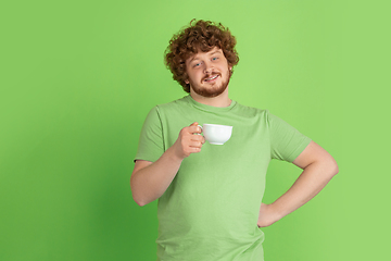 Image showing Caucasian young man\'s monochrome portrait on green studio background