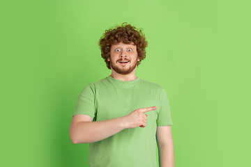 Image showing Caucasian young man\'s monochrome portrait on green studio background