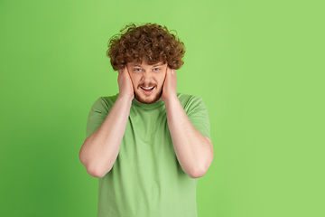 Image showing Caucasian young man\'s monochrome portrait on green studio background