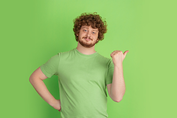 Image showing Caucasian young man\'s monochrome portrait on green studio background