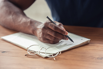 Image showing Close up of african-american male hands, working in office