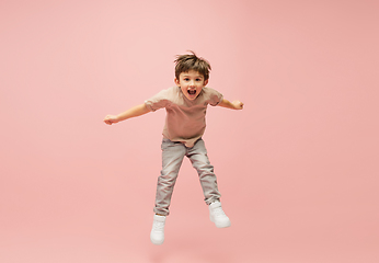 Image showing Happy caucasian little boy isolated on pink studio background. Looks happy, cheerful, sincere. Copyspace. Childhood, education, emotions concept