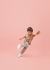 Image showing Happy caucasian little boy isolated on pink studio background. Looks happy, cheerful, sincere. Copyspace. Childhood, education, emotions concept