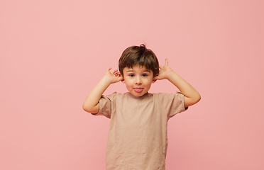 Image showing Happy caucasian little boy isolated on pink studio background. Looks happy, cheerful, sincere. Copyspace. Childhood, education, emotions concept