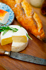 Image showing French cheese and fresh  baguette on a wood cutter