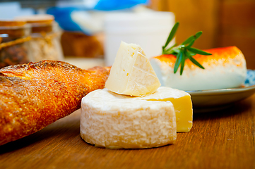 Image showing French cheese and fresh  baguette on a wood cutter