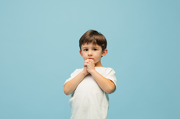 Image showing Happy caucasian little boy isolated on blue studio background. Looks happy, cheerful, sincere. Copyspace. Childhood, education, emotions concept