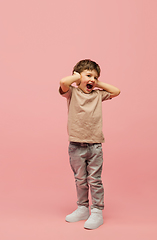 Image showing Happy caucasian little boy isolated on pink studio background. Looks happy, cheerful, sincere. Copyspace. Childhood, education, emotions concept