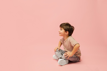 Image showing Happy caucasian little boy isolated on pink studio background. Looks happy, cheerful, sincere. Copyspace. Childhood, education, emotions concept