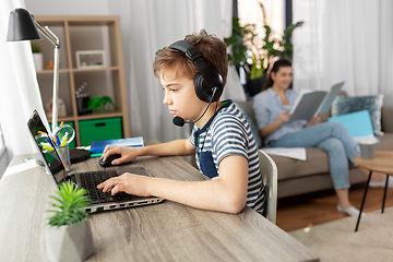 Image showing boy with laptop and headphones at home