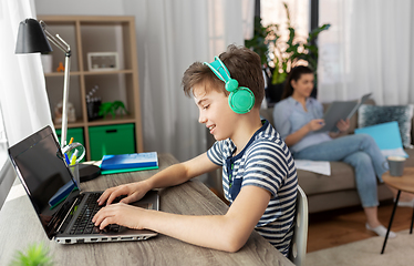 Image showing boy with laptop and headphones at home