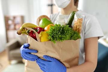 Image showing woman in gloves with food in paper bag at home