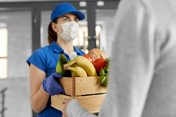 Image showing delivery woman in mask giving food to customer