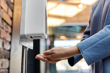 Image showing close up of woman at dispenser with hand sanitizer