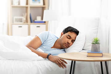 Image showing indian man with tracker sleeping in bed at home