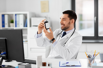 Image showing smiling male doctor with medicine at hospital